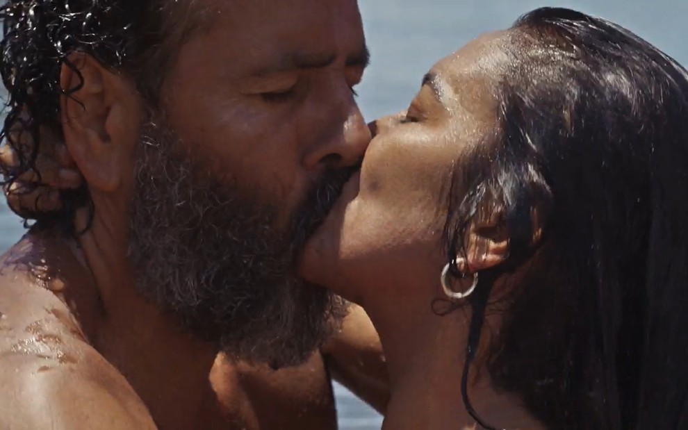 Marcos Palmeira, caracterizado como José Leôncio, e Dira Paes, a Filó, estão com o corpo molhado; eles se beijam intensamente em cena de Pantanal