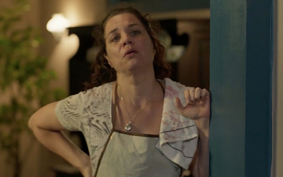 Isabel Teixeira em cena da novela Pantanal: vestida com vestido simples e avental, atriz olha para alguém fora do quadro