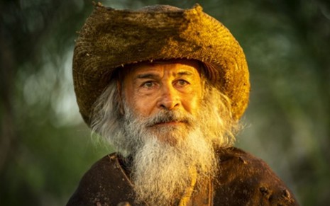 Osmar Prado com expressão séria, barba branca longa, como o Velho do Rio na novela Pantanal