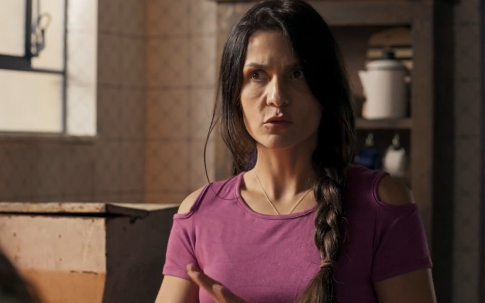 Paula Barbosa caracterizada como Zefa em Pantanal: atriz têm os cabelos presos em uma trança lateral e exibe o semblante chocado em cena de Pantanal