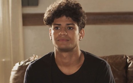 Gabriel Santana, caracterizado como Renato, tem a expressão emburrada em cena de Pantanal