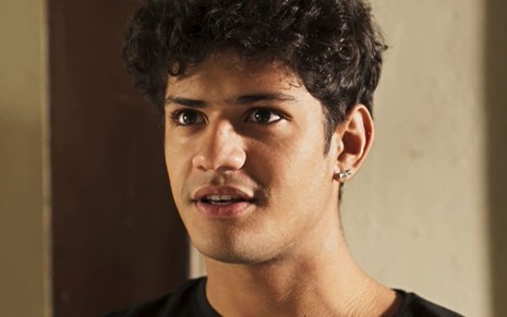 Gabriel Santana, caracterizado como Renato, tem a expressão perturbada e séria em cena de Pantanal
