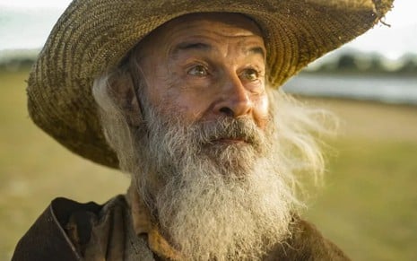 Osmar Prado tem a barba longa e a expressão sorridente em cena de Pantanal
