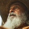 O ator Osmar Prado, caracterizado como Velho do Rio, usa chapéu e exibe um olhar assustado em cena de Pantanal, novela das nove da Globo
