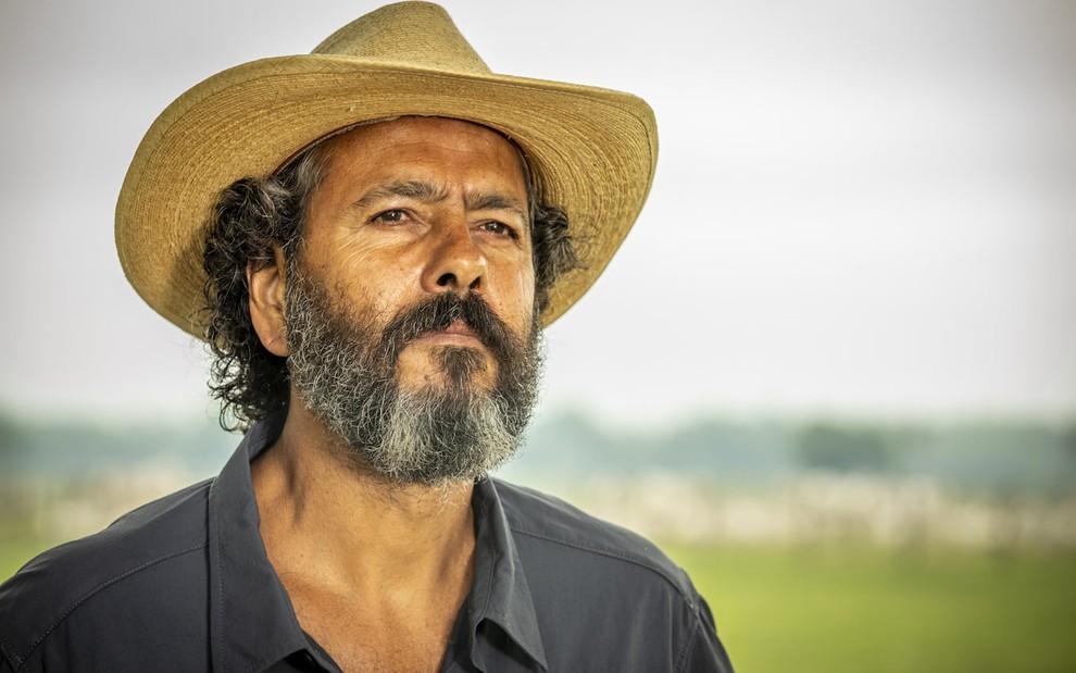 O ator Marcos Palmeira está com barba grande e usa chapéu e camisa escura em cena de Pantanal, novela das nove da Globo