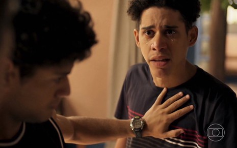 O ator Cauê Campos chora em cena de Pantanal na qual seu personagem, Roberto, é empurrado para trás
