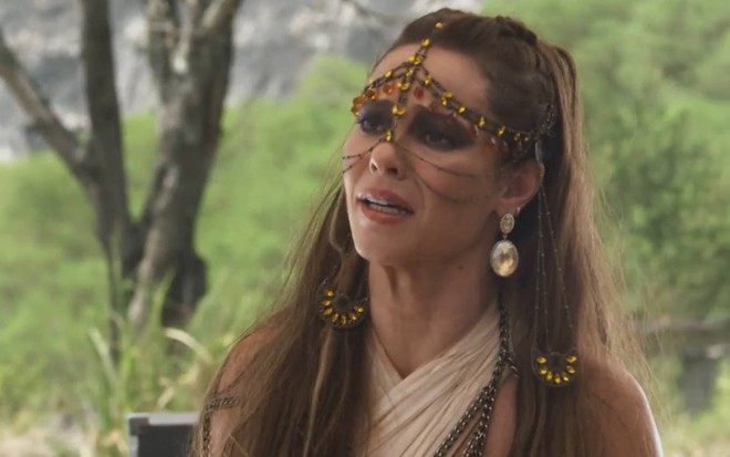 Atriz Paolla Oliveira olha para frente com cara de assustada em cena de Cara e Coragem, novela das sete da Globo; ela está com uma maquiagem de fantasia no rosto