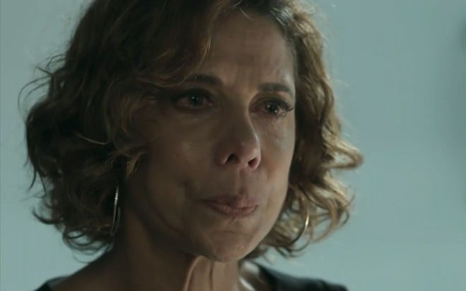 Lígia (Angela Vieira) chora sentada em sala de delegacia em cena de Pega Pega