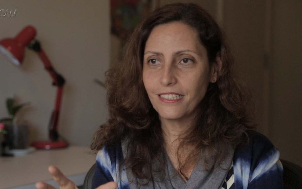 A autora Claudia Souto em entrevista sobre Pega Pega. Ela sorri amarelo