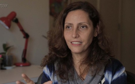 A autora Claudia Souto em entrevista sobre Pega Pega. Ela sorri amarelo
