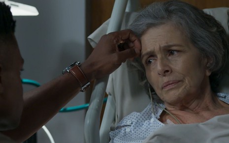 Irene Ravache grava cena em cama de hospital, com expressão tensa, como Sabine em Pega Pega