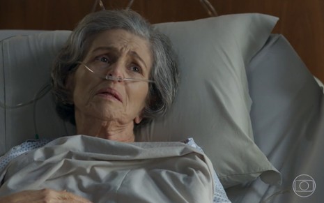 Irene Ravache em cena como a ricaça Sabine da novela Pega Pega; ela está em uma cama de hospital