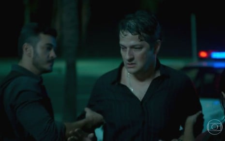 Malagueta (Marcelo Serrado) é algemado por Domênico (Marcos Veras) no calçadão de Copacabana em cena de Pega Pega