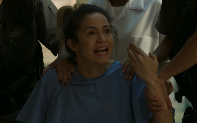 Nanda Costa grava cena em cadeira de rodas como paciente de hospital, com expressão desesperada, como Sandra Helena
