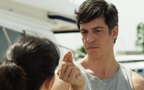 Mateus Solano, interpretando Flávia no corpo de Guilherme, segura aliança e encara Valentina Herszage em cena de Quanto Mais Vida, Melhor!