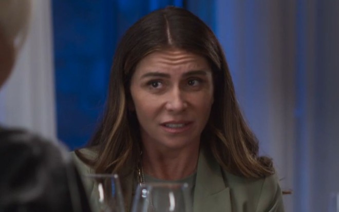 Giovanna Antonelli grava cena com expressão desconfiada, como Paula/Neném em Quanto Mais Vida, Melhor!