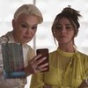 Julia Lemmertz grava cena olhando para um celular, ao lado de Giovanna Antonelli, como Carmem e Paula