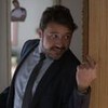 Thardelly Lima em cena de Quanto Mais Vida, Melhor: caracterizado como Odaílson, ator está de terno, gravata e olha para alguém fora do quadro