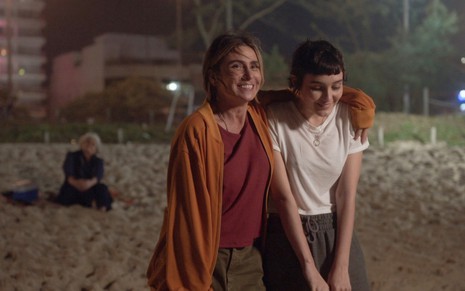 Giovanna Antonelli, interpretando Neném no corpo de Paula, usa roupa despojadas enquanto abraça Nina Tomsic, a Ingrid, em cena de Quanto Mais Vida, Melhor!