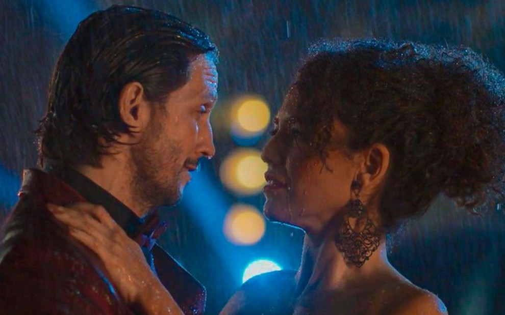 Vladimir Brichta e Bárbara Colen em cena de Quanto Mais Vida, Melhor!: atores estão de frente um para o outro durante uma chuva