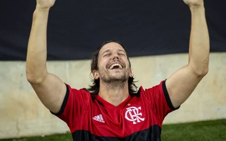Neném (Vladimir Brichta) usa camiseta do Flamengo e vibra em campo em cena de Quanto Mais Vida, Melhor!