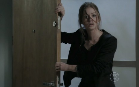 A atriz Marina Ruy Barbosa, segurando uma porta, toda descabelada, em cena como Maria Isis em Império