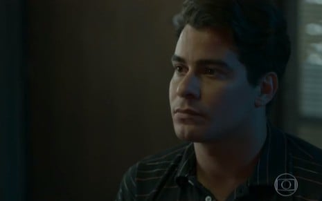 O ator Thiago Martins, com uma camisa escura, em cena como Júlio na novela Pega Pega