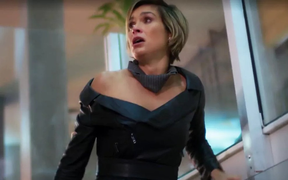 A atriz Flávia Alessandra com uma roupa preta, descendo as escadas e chorando, em cena como Helena em Salve-se Quem Puder