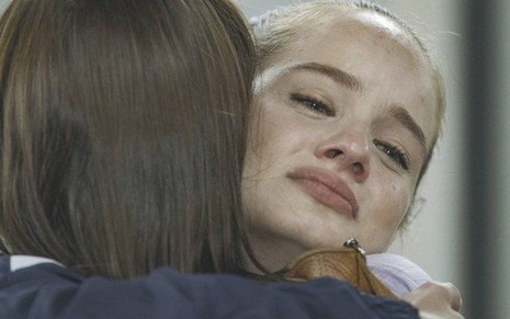 A atriz Valentina Bulc, chorando abraçada à atriz Vitória Strada, em cena de reencontro entre Bia e Kyra/Cleyde em Salve-se Quem Puder