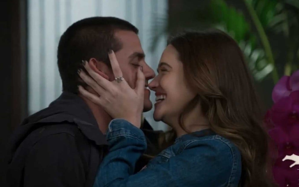 O ator Felipe Simas como Téo tem o rosto segurado pelas duas mão de Juliana Paiva, a Luna, que está prestes a lhe dar um beijo em cena de Salve-se Quem Puder