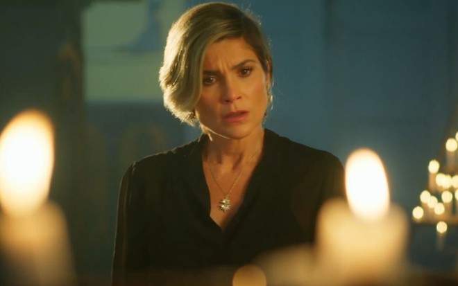 Flávia Alessandra em cena de Salve-se Quem Puder: caracterizada como Helena, atriz olha com seriedade para alguém fora do quadro