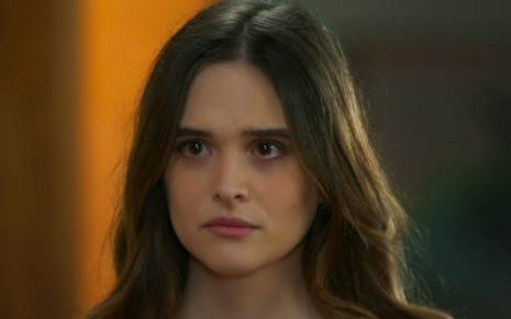 Juliana Paiva caracterizada como Luna em cena de Salve-se Quem Puder: ela olha alguém de fora com indignação