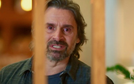 O ator Murilo Rosa tem expressão de raiva em gravação de cena em que ele está observando algo por meio de uma janela