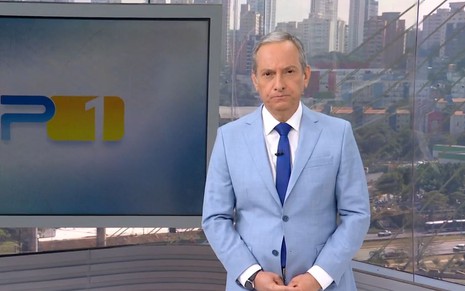 De terno azul, José Roberto Burnier tem expressão séria no cenário do SP1, da Globo