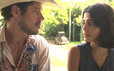 Tadeu (José Loreto) e Guta (Julia Dalavia) estão sentados lado a lado em cena de Pantanal, novela das nove da Globo
