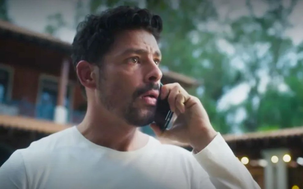 O ator Cauã Reymond caracterizado como Caio fala ao telefone em cena de Terra e Paixão