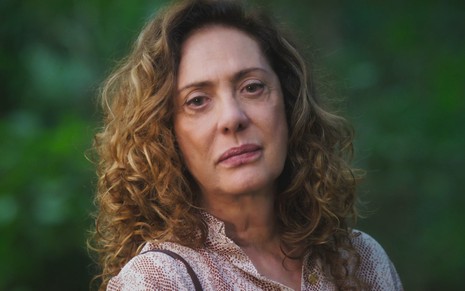 A atriz Eliane Giardini caracterizada como Agatha em Terra e Paixão, com expressão séria, olhando para a câmera