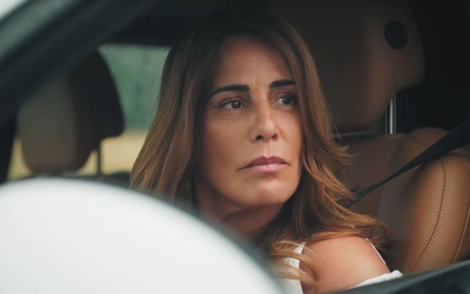 Gloria Pires caracterizada como Irene; ela tem os cabelos escuros e o semblante furioso em cena de Terra e Paixão. Ao fundo, Tony Ramos, o Antônio, a encara com desdém