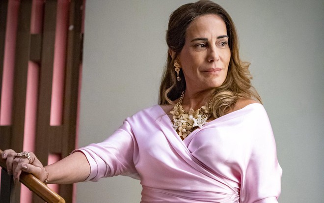 Gloria Pires usa blusa rosa e penteado lateral caracterizada como Irene da novela Terra e Paixão, da Globo