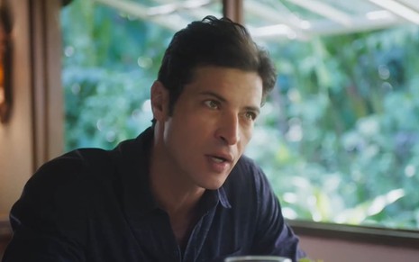 Leandro Lima caracterizado como Marino; ator usa uma camisa branca e parece tenso em cena da novela.