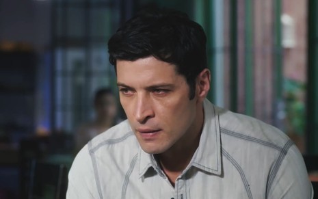 Leandro Lima caracterizado como Marino; ator usa uma camisa branca e parece furioso em cena da novela.