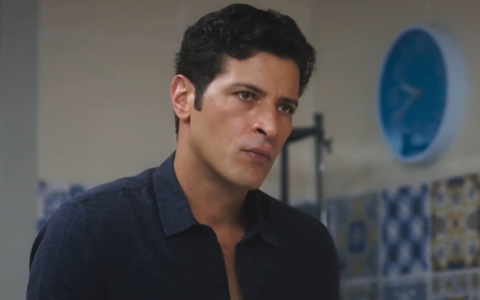 Leandro Lima caracterizado como Marino; ator usa uma camisa azul e parece tenso em cena de Terra e Paixão