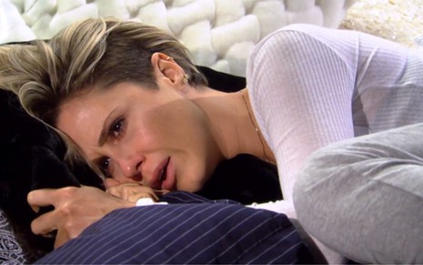 Guilhermina Guinle em cena de Ti Ti Ti, atriz está caracterizada como Luísa e está deitada de lado na cama com a expressão de choro