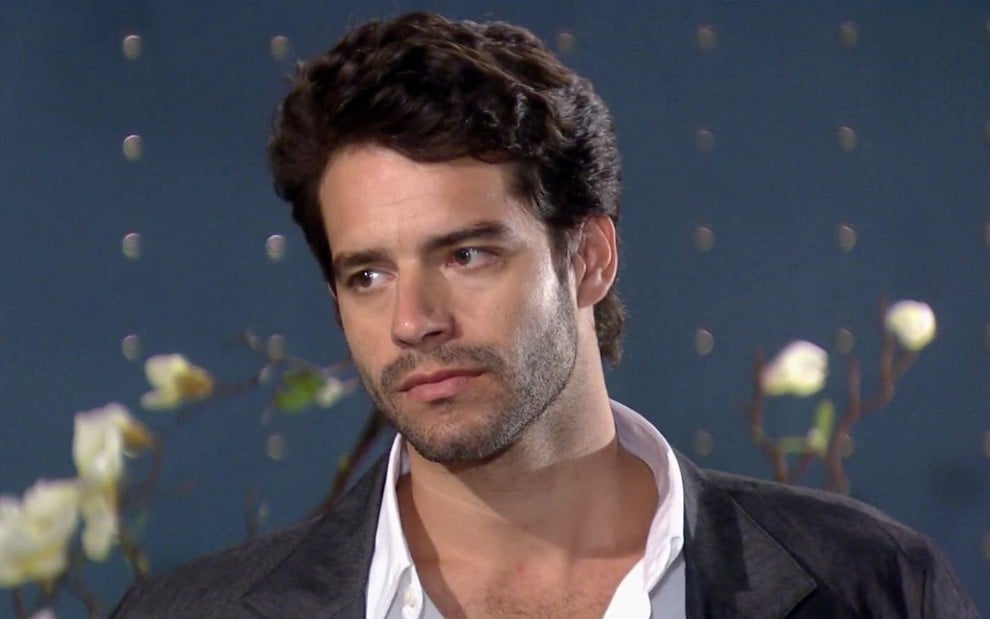 Guilherme Winter em cena de Ti Ti Ti: caracterizado com Renato, ator olha para fora com expressão de seriedade