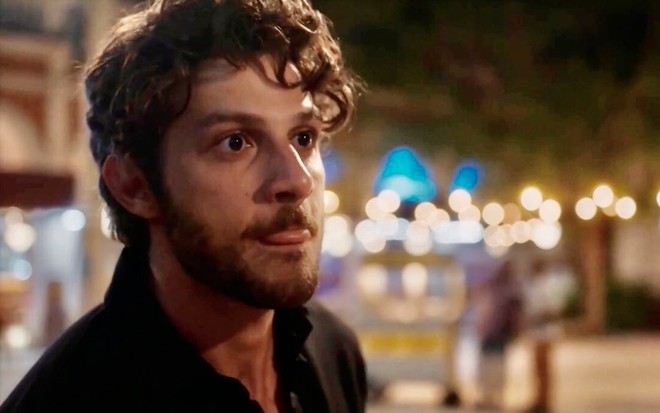 O ator Chay Suede morde a língua e faz uma careta em cena de Travessia como o personagem Ari