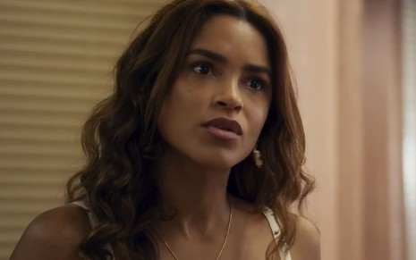 Lucy Alves caracterizada como Brisa; atriz usa um cropped florido e tem a expressão transtornada em cena de Travessia