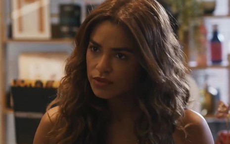 Lucy Alves caracterizada como Brisa; ela tem a expressão confusa e indignada em cena de Travessia