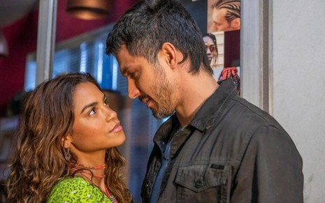 Os atores Lucy Alves e Romulo Estrela como Brisa e Oto em Travessia; eles estão se olhando frente a frente com os rostos quase próximos