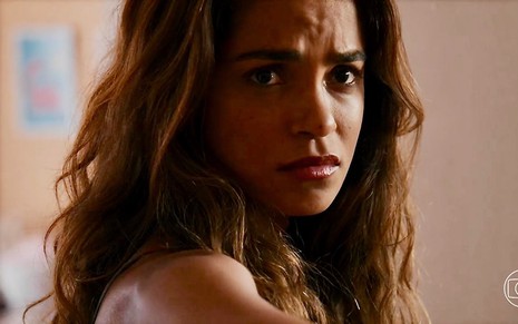 A atriz Lucy Alves faz uma expressão de sofrimento em cena de Travessia na qual está com cabelos soltos como a mocinha Brisa
