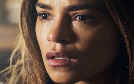 A atriz Lucy Alves está em close com lágrimas caindo de seus olhos em cena da novela Travessia, da Globo